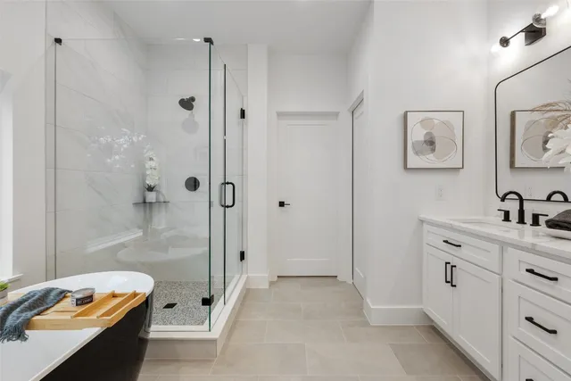a bathroom with a tub sink vanity and mirror