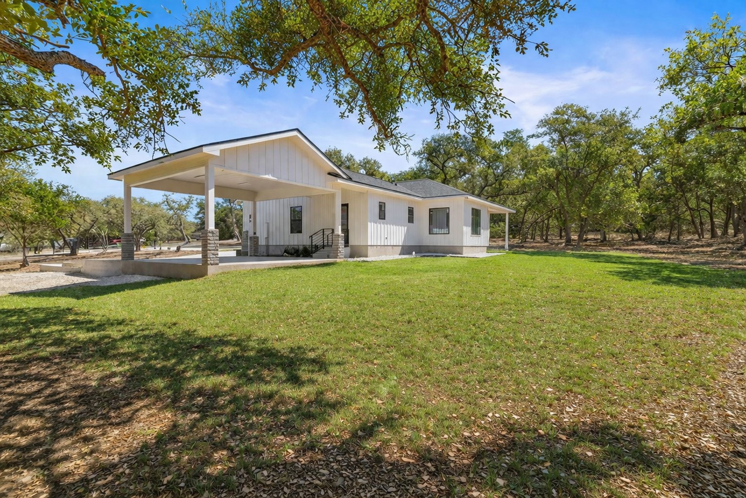 408 Rust Ranch Road Blanco, TX 78606 - Photo 27 of 34 Rear view of property with a lawn, board and batten siding, and a porch