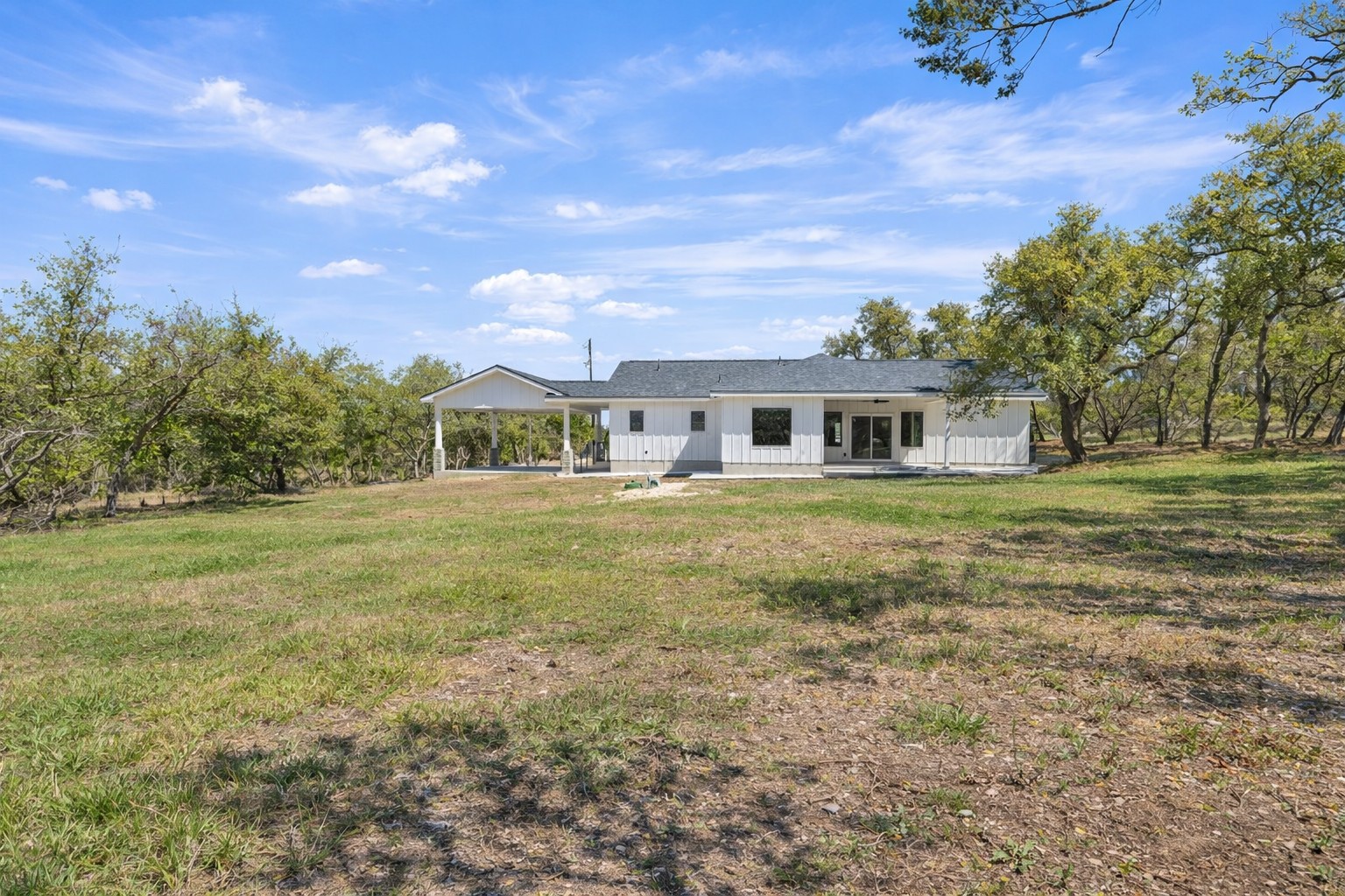 408 Rust Ranch Road Blanco, TX 78606 - Photo 31 of 34 Rear view of house with a yard and a porch