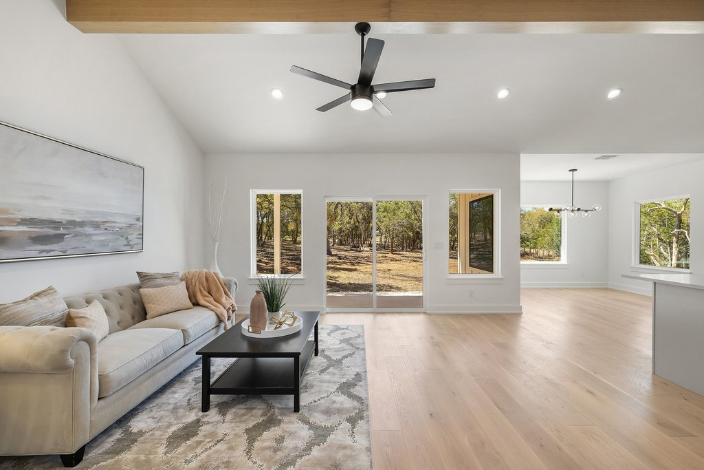 408 Rust Ranch Road Blanco, TX 78606 - Photo 4 of 34 Living room featuring ceiling fan, light wood finished floors, a chandelier, and vaulted ceiling with beams