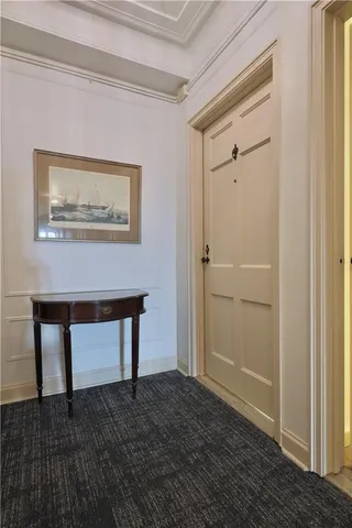a view of a hallway with wooden floor and a rug