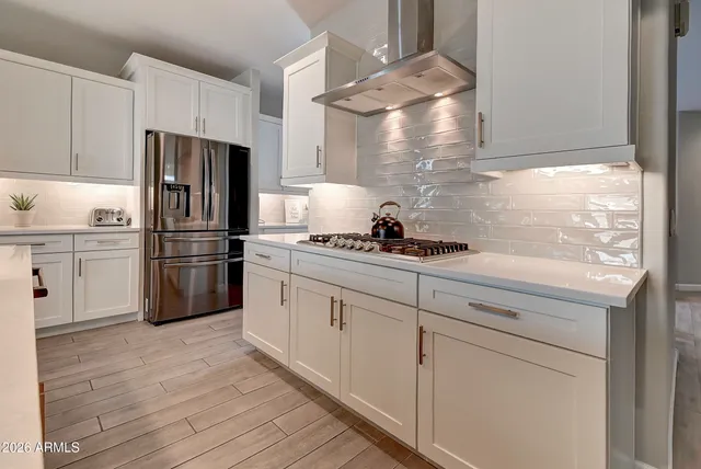 a kitchen with cabinets stainless steel appliances and a window