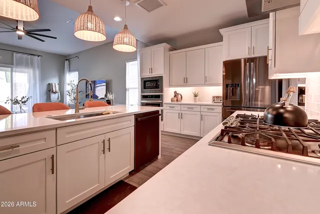 a kitchen with kitchen island granite countertop a sink a stove and refrigerator