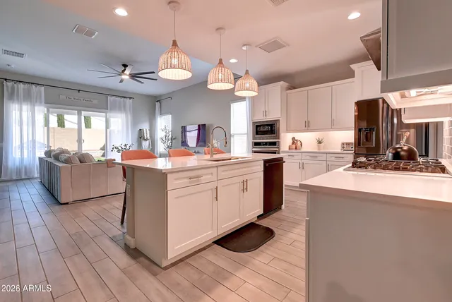 a kitchen with kitchen island granite countertop a stove and a sink