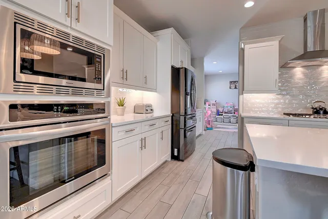 a kitchen with stainless steel appliances a stove microwave and refrigerator