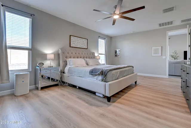 a spacious bedroom with a bed and a ceiling fan
