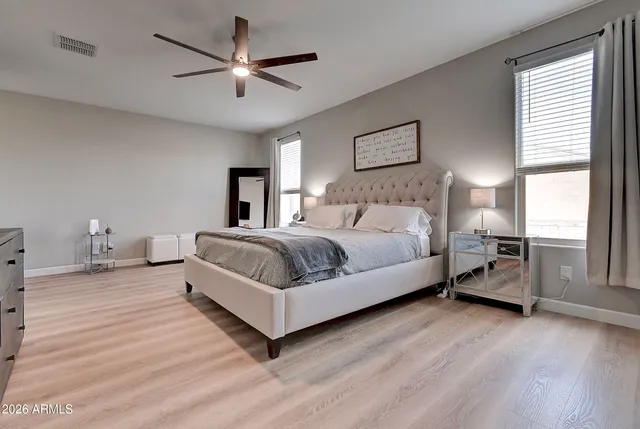 a spacious bedroom with a bed and a flat screen tv