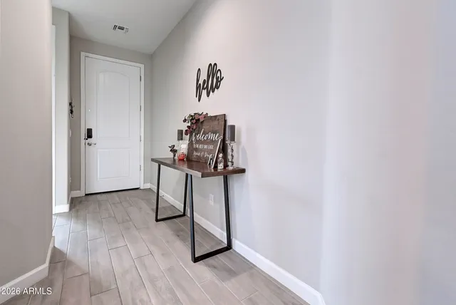 a view of a hallway with wooden floor and entryway