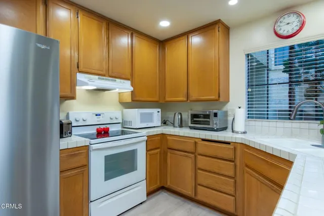 a kitchen with yellow cabinets and white appliances