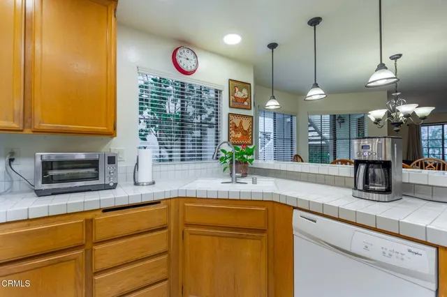 a kitchen with granite countertop a sink a counter space cabinets and stainless steel appliances