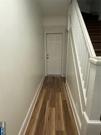 a view of a hallway with wooden floor and stairs