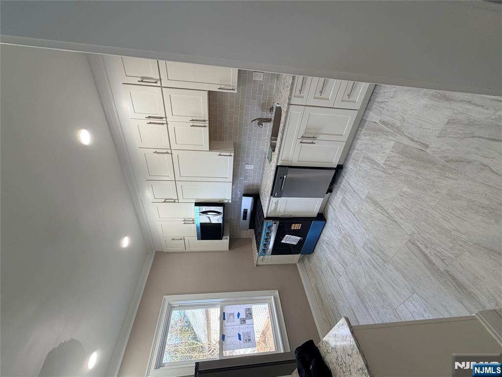 46 High Street Clifton, NJ 07014 - Photo 3 of 14 a kitchen with stainless steel appliances granite countertop a stove sink and cabinets
