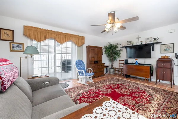 a living room with furniture a flat screen tv and a floor to ceiling window