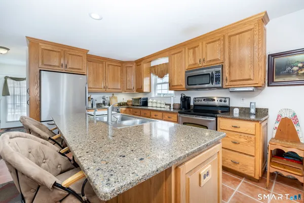 a kitchen with stainless steel appliances granite countertop a refrigerator stove microwave and sink