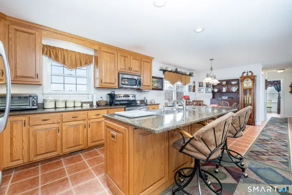 a kitchen with stainless steel appliances granite countertop a stove a sink and a refrigerator