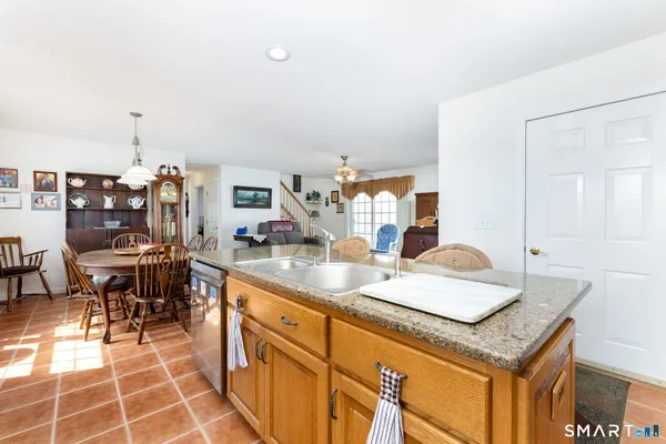 a dining hall with stainless steel appliances granite countertop a sink and a table