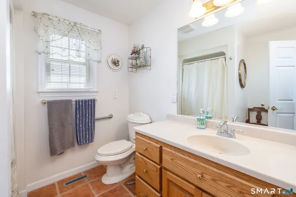 a bathroom with a granite countertop sink a toilet and a mirror