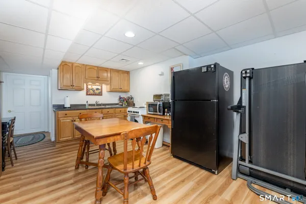 a kitchen with stainless steel appliances a refrigerator a sink a stove a dining table and chairs