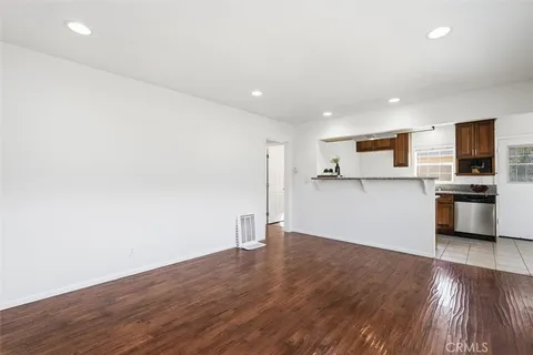 a view of a kitchen with a sink and wooden floor