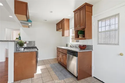 a kitchen with stainless steel appliances granite countertop a stove top oven a sink a counter space and cabinets