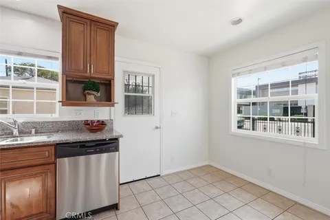 a kitchen with granite countertop white cabinets and window