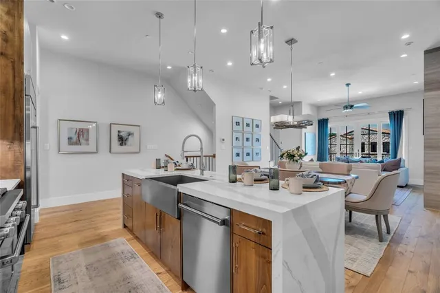 a kitchen with stainless steel appliances granite countertop a sink a stove a dining table and chairs