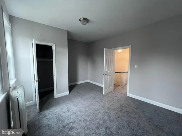 an empty room with closet and mirror