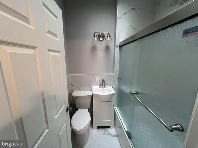 a bathroom with a sink a toilet and a shower