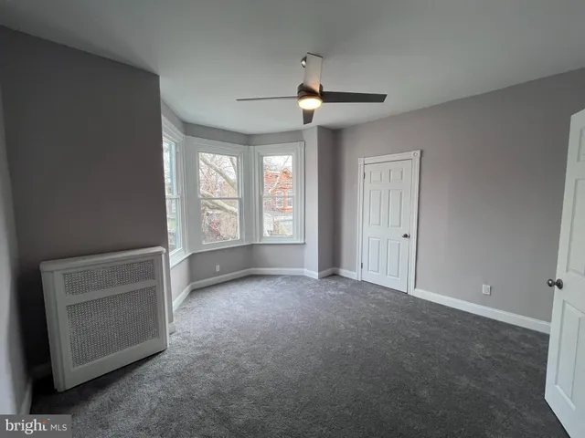 an empty room with windows and cabinet