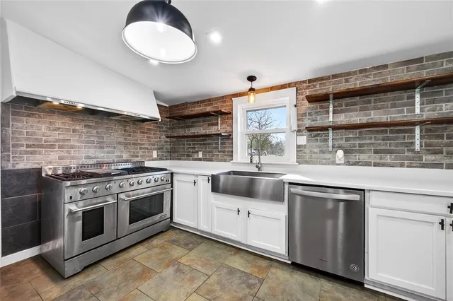 a large kitchen with stainless steel appliances granite countertop a stove and a sink