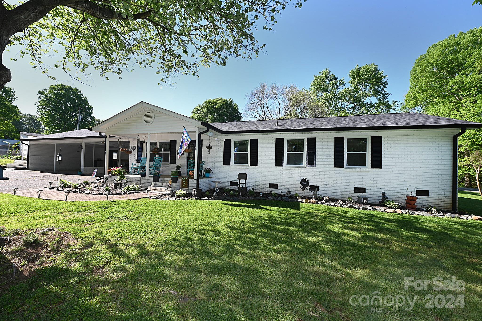 a front view of house with yard barbeque and outdoor seating