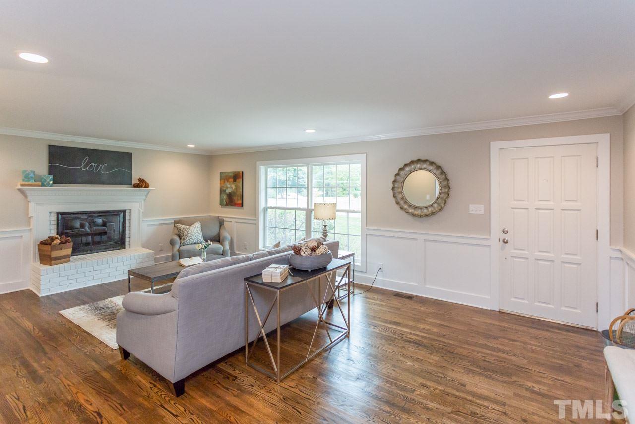 3705 Edwards Mill Road Raleigh, NC 27612 - Photo 4 of 25 a living room with furniture a fireplace and a large window