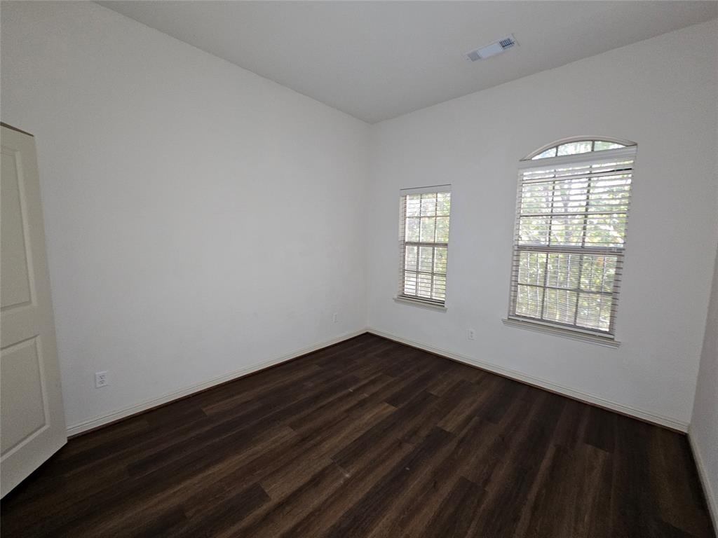 8627 Calvin Road Irving, TX 75063 - Photo 18 of 33 an empty room with wooden floor and windows