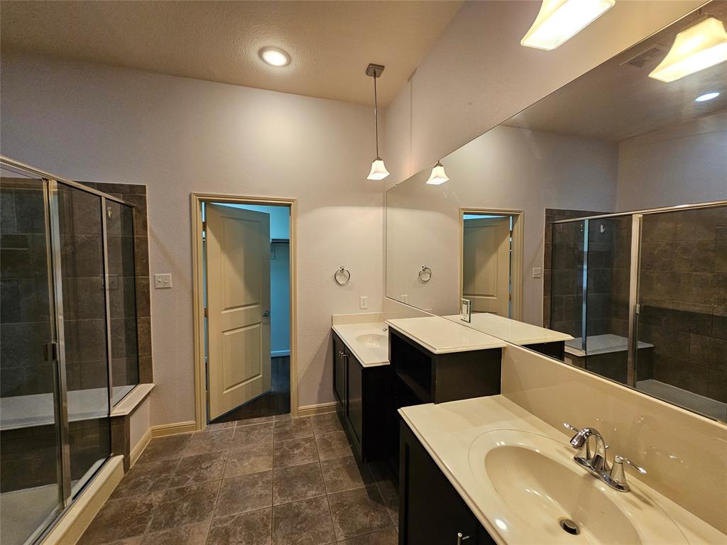 8627 Calvin Road Irving, TX 75063 - Photo 27 of 33 a bathroom with a double vanity sink mirror and shower