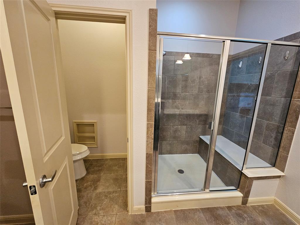 8627 Calvin Road Irving, TX 75063 - Photo 28 of 33 a bathroom with a shower and toilet