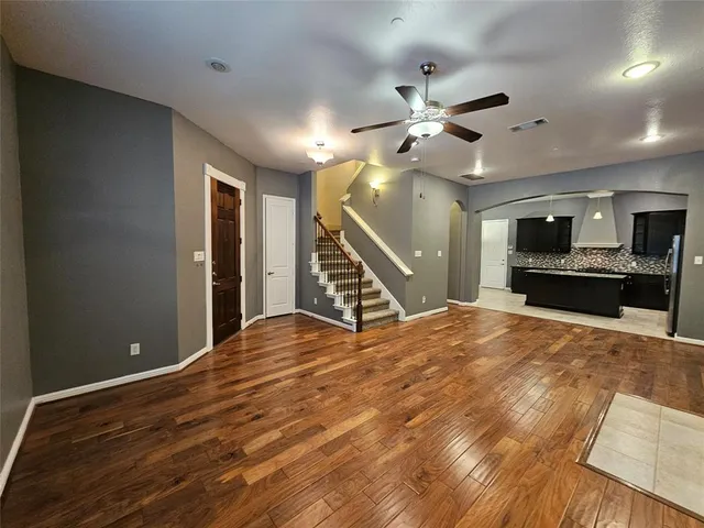 a view of an empty room with a fireplace and a ceiling fan