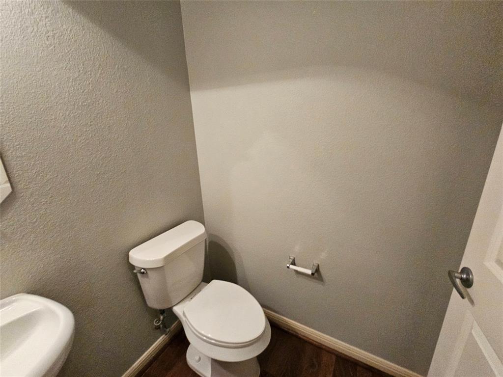 8627 Calvin Road Irving, TX 75063 - Photo 7 of 33 a white toilet sitting next to a white wall