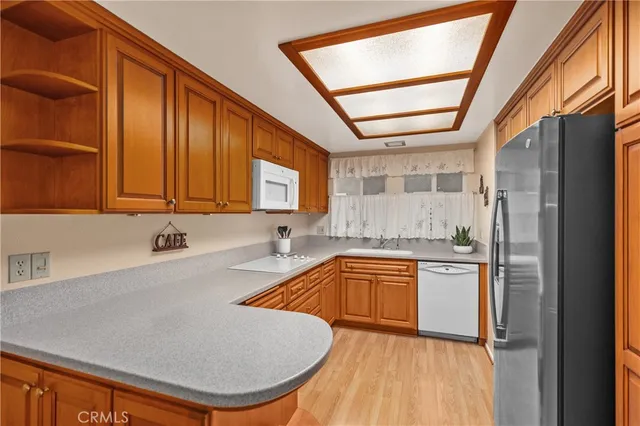 a kitchen with stainless steel appliances granite countertop a sink refrigerator and cabinets