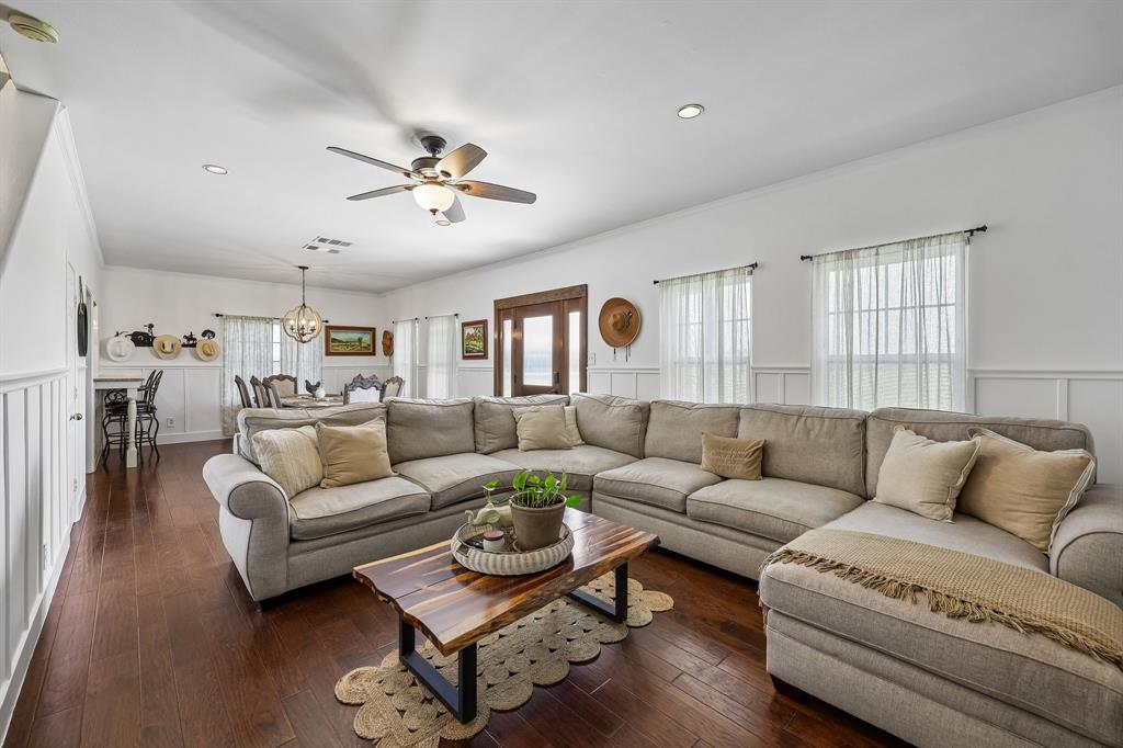 331 Radecke Road Krum, TX 76249 - Photo 10 of 40 Open-concept living area featuring rich wood-finish flooring, white wainscoting, and recessed lighting
