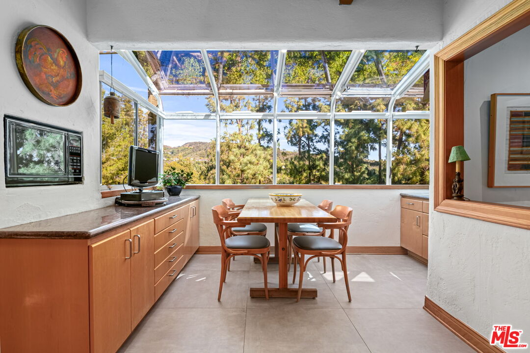 13360 Chalon Road Los Angeles, CA 90049 - Photo 18 of 69 a dining room with a large window and a table