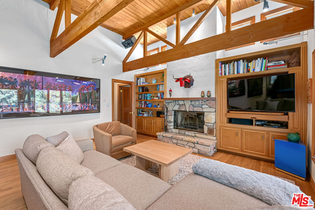13360 Chalon Road Los Angeles, CA 90049 - Photo 24 of 69 a living room with furniture a flat screen tv and a fireplace