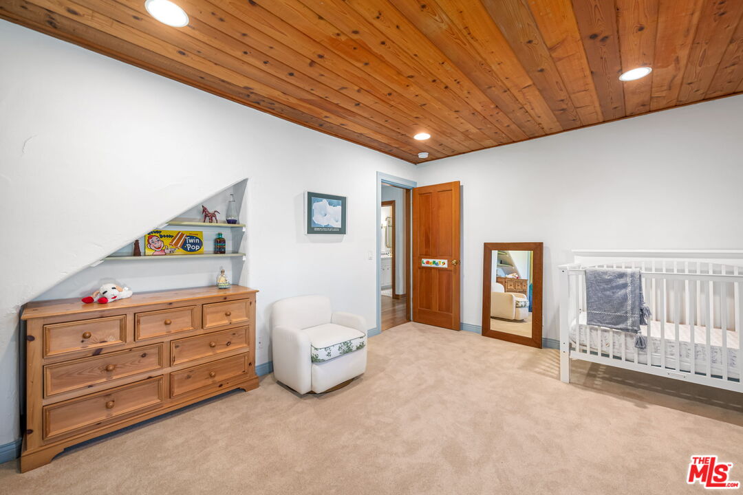 13360 Chalon Road Los Angeles, CA 90049 - Photo 34 of 69 a spacious bedroom with a bed and a cabinets