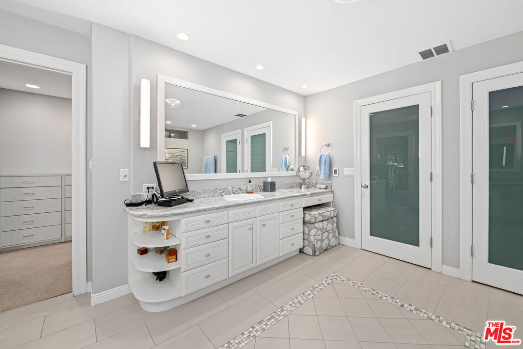 13360 Chalon Road Los Angeles, CA 90049 - Photo 42 of 69 a spacious bathroom with a double vanity sink and a mirror