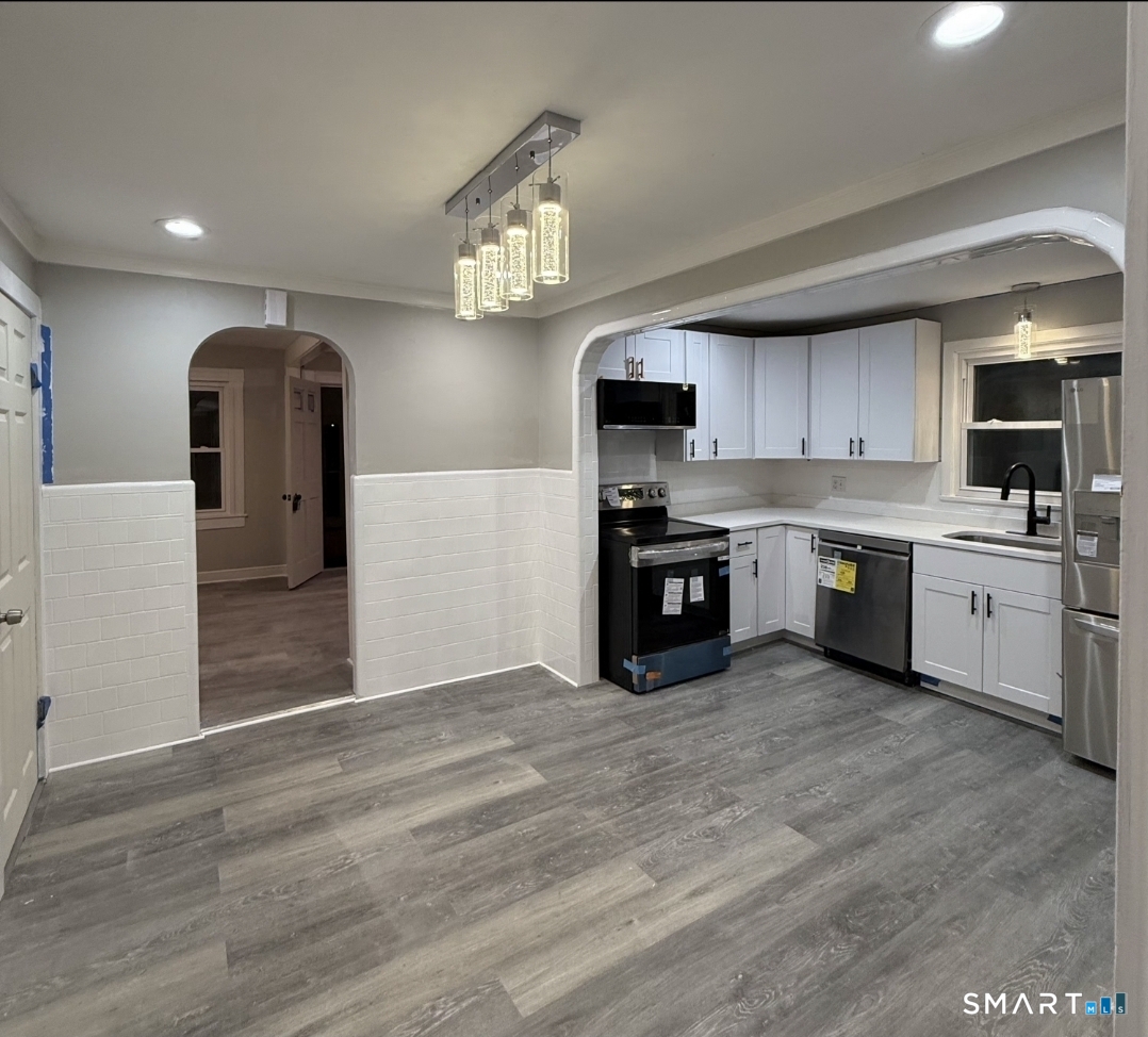 12 Mechanic Street Moosup, CT 06354 - Photo 4 of 8 a large kitchen with stainless steel appliances granite countertop a stove a sink and a refrigerator