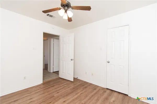 a view of an empty room with wooden floor