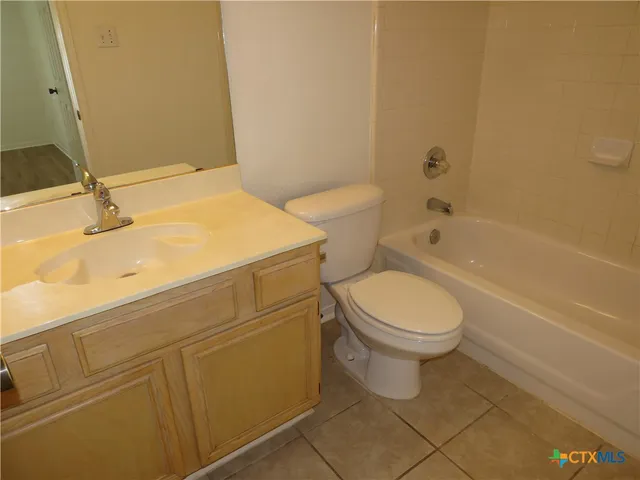 a white toilet sitting next to a bathroom sink and vanity