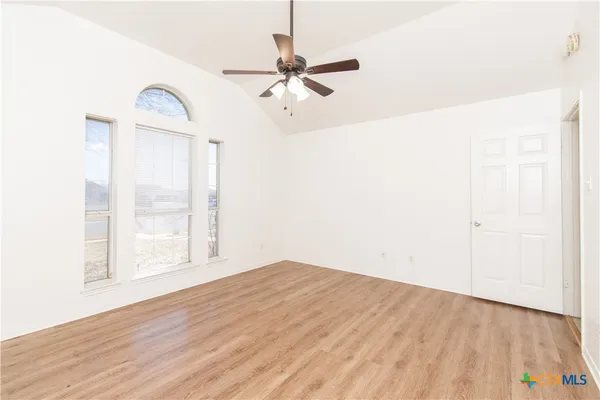 a view of a room with wooden floor and a ceiling fan