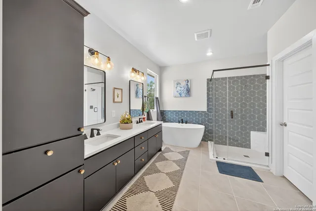 a spacious bathroom with a double vanity sink toilet mirror and bathtub