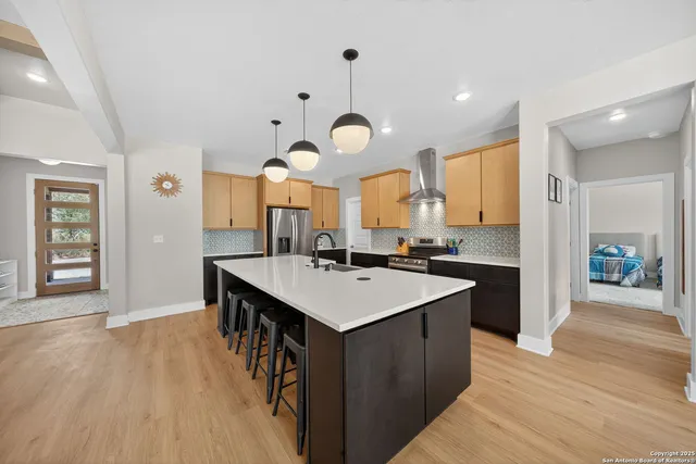 a large kitchen with stainless steel appliances a large center island and a wooden floors