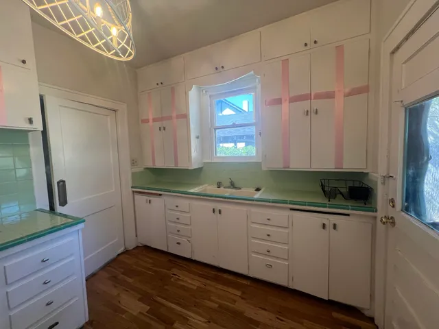 a kitchen with granite countertop white cabinets and a sink
